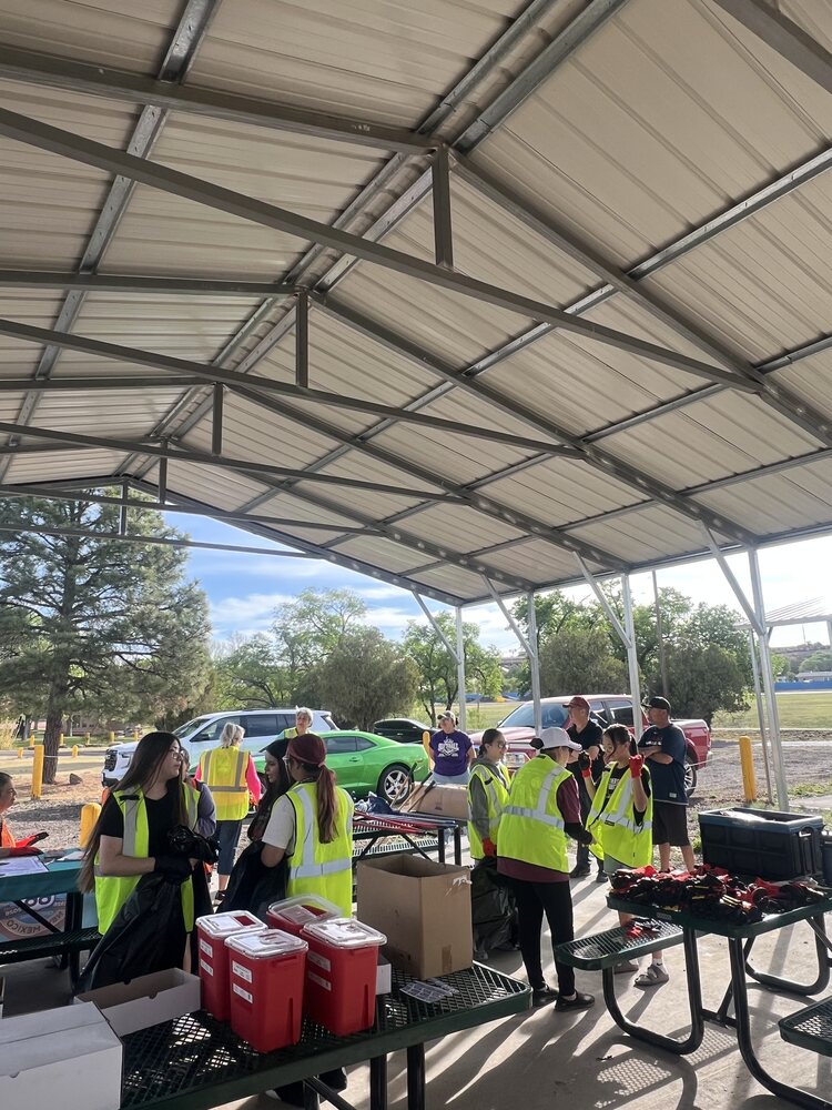 Student and community volunteers gathering cleanup equipment on Earth Day